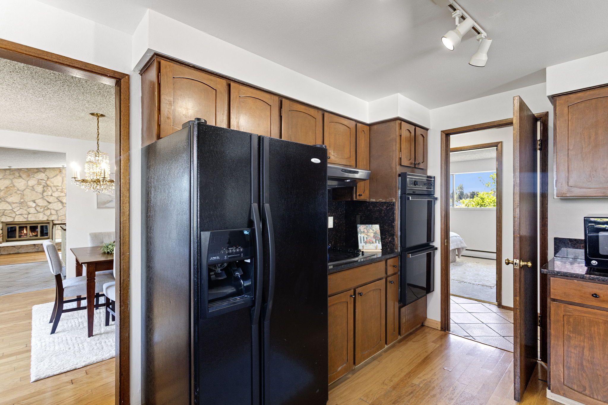 Double wall ovens, track lighting — and that's the stone fireplace through the doorway.