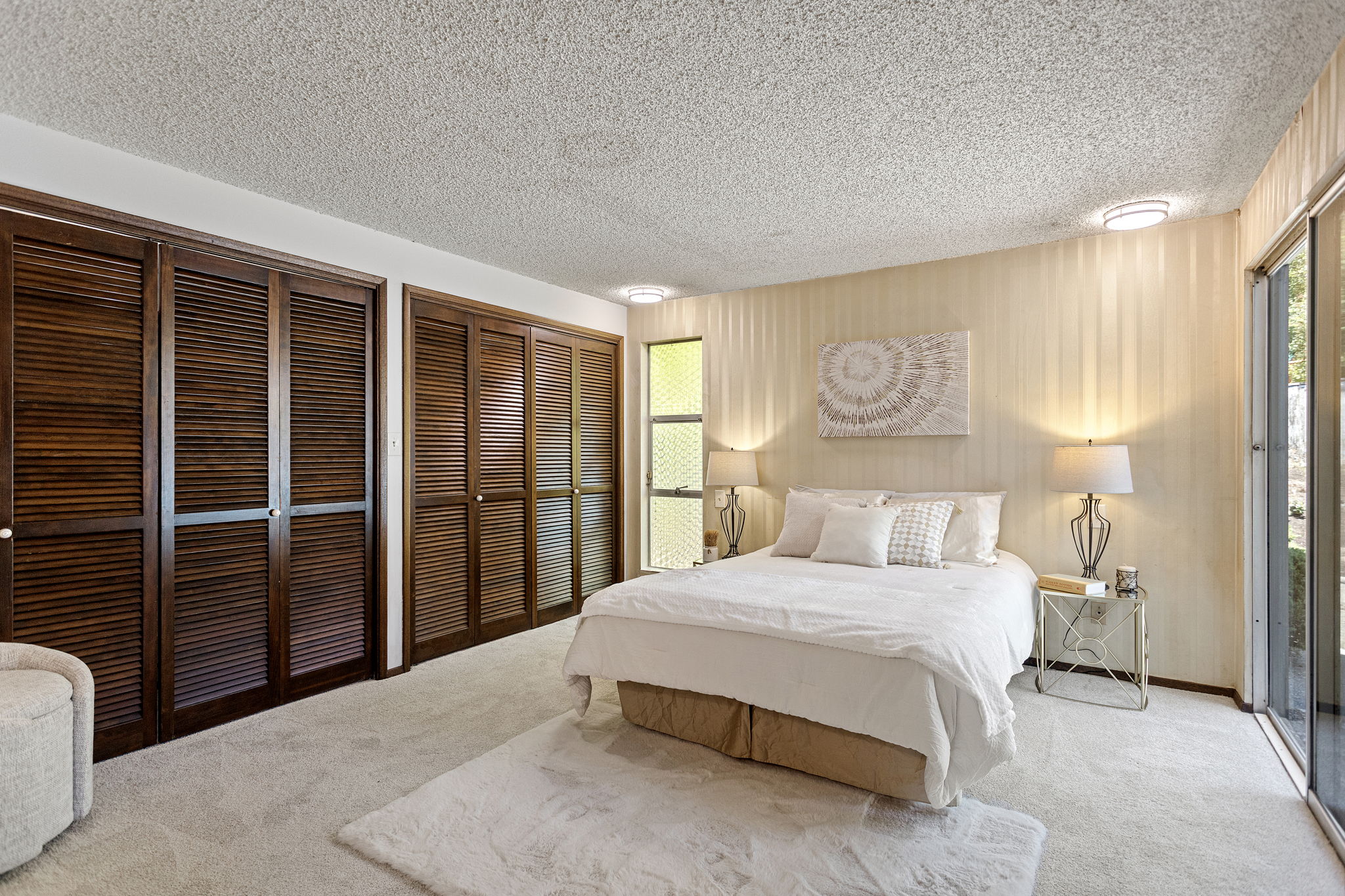 The primary suite is — let's be honest — a master suite. Self-contained escape with two closets, patio access, en suite bath, and room for a king.