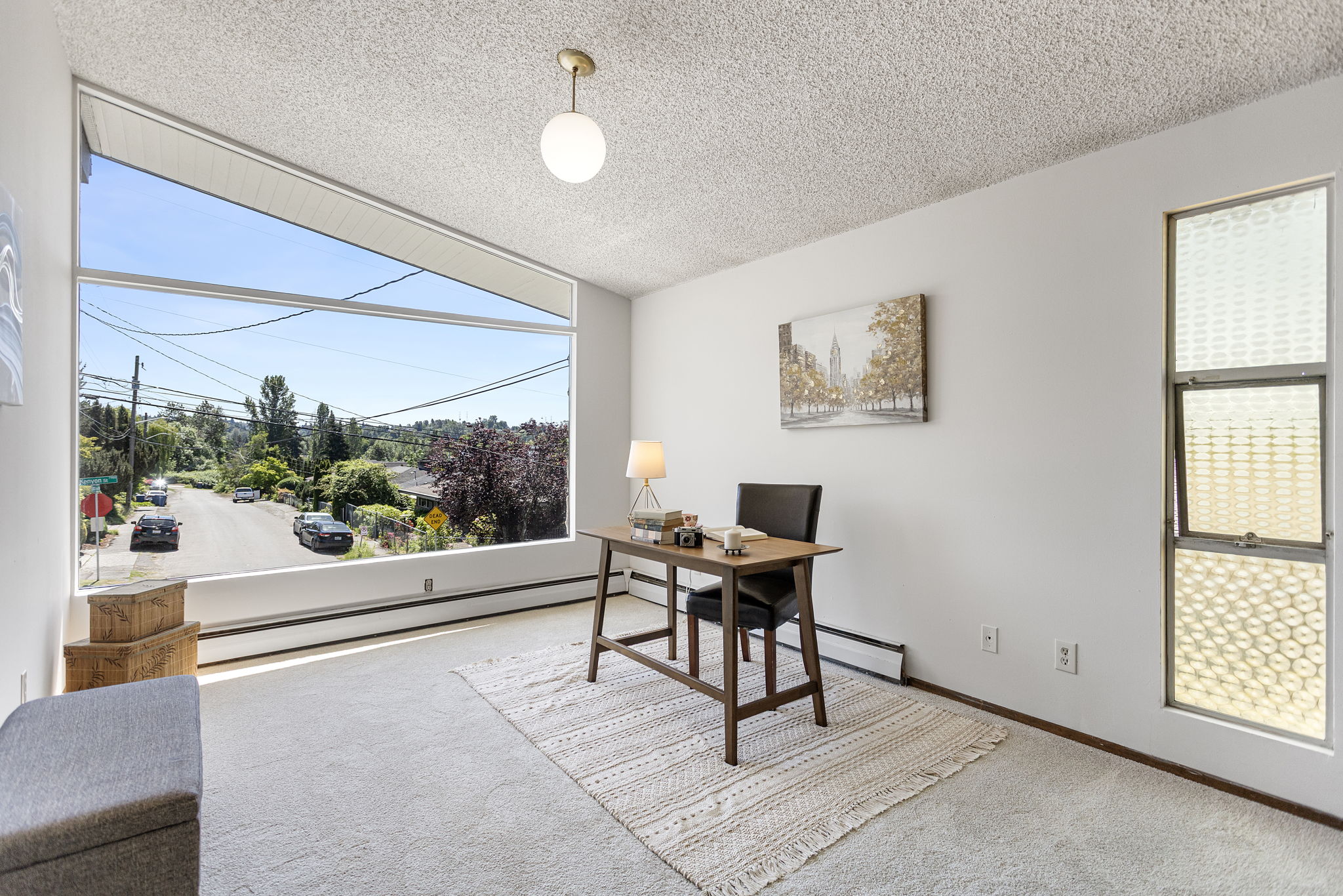 Five bedrooms and this. The front den is exceptional — vaulted ceiling, new oversized corner window with south-facing territorial views, wood-paneled wall with built-in shelving, brand-new carpet. Call it what you need it to be.