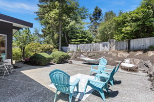 Concrete aggregate patio, mature shrubs, boulders, hammock, full sun. Seward Park summer starts here.