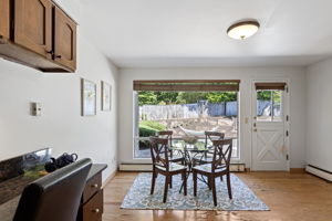 Second dining area with picture window to the back patio, exterior door, and a built-in desk in the corner.