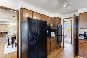 Double wall ovens, track lighting — and that's the stone fireplace through the doorway.