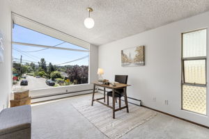 Five bedrooms and this. The front den is exceptional — vaulted ceiling, new oversized corner window with south-facing territorial views, wood-paneled wall with built-in shelving, brand-new carpet. Call it what you need it to be.
