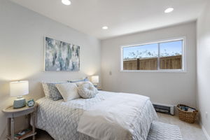 Lower bedroom 4 — west-facing window, recessed lighting, full closet with its own light, tile floor. Front of the lower level, just behind the garage.