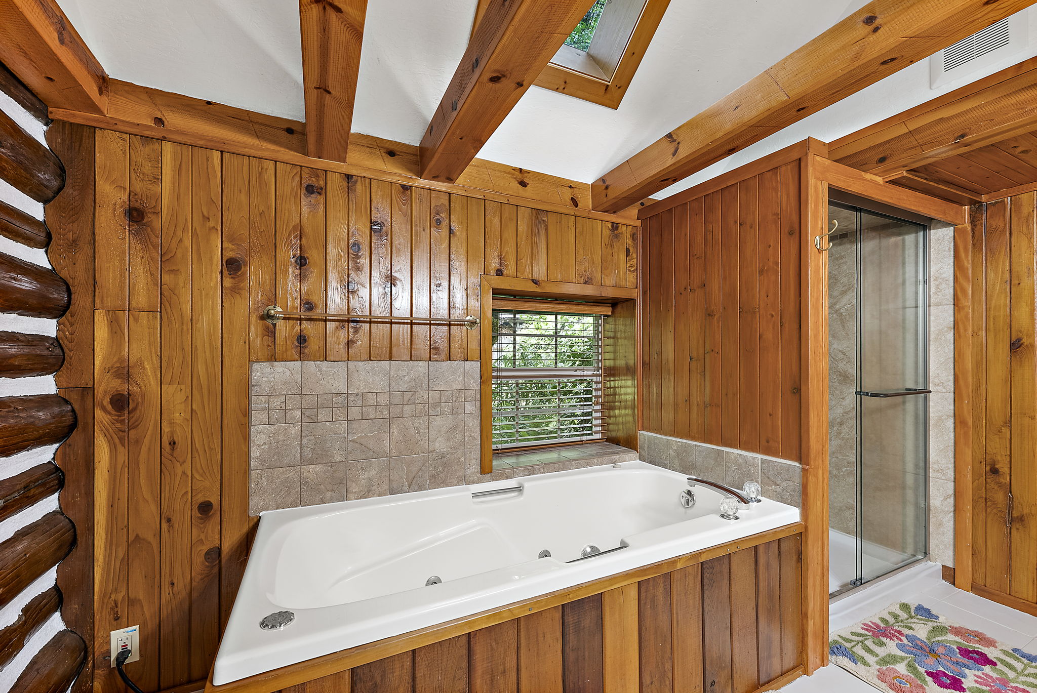 Large jetted tub, with window into private backyard. Large separate shower.