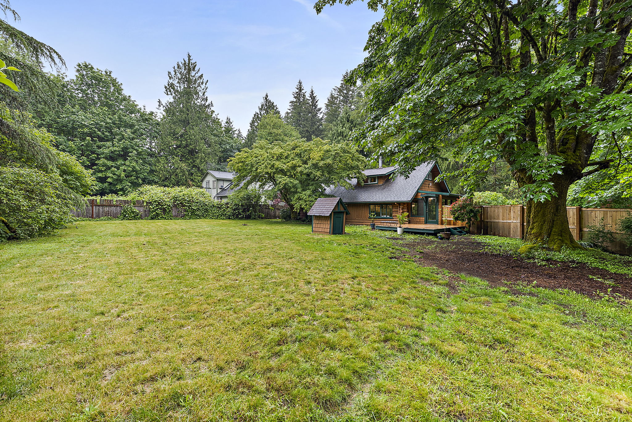 Fully fenced, surrounded by lush foliage.