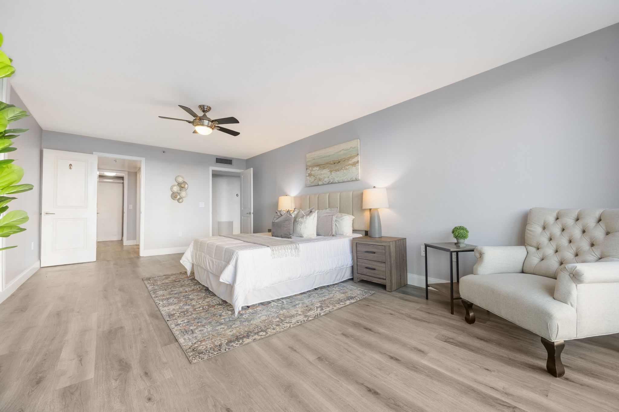 Primary bedroom looking into ensuite bath to the left and entrance hall to the right off main living.