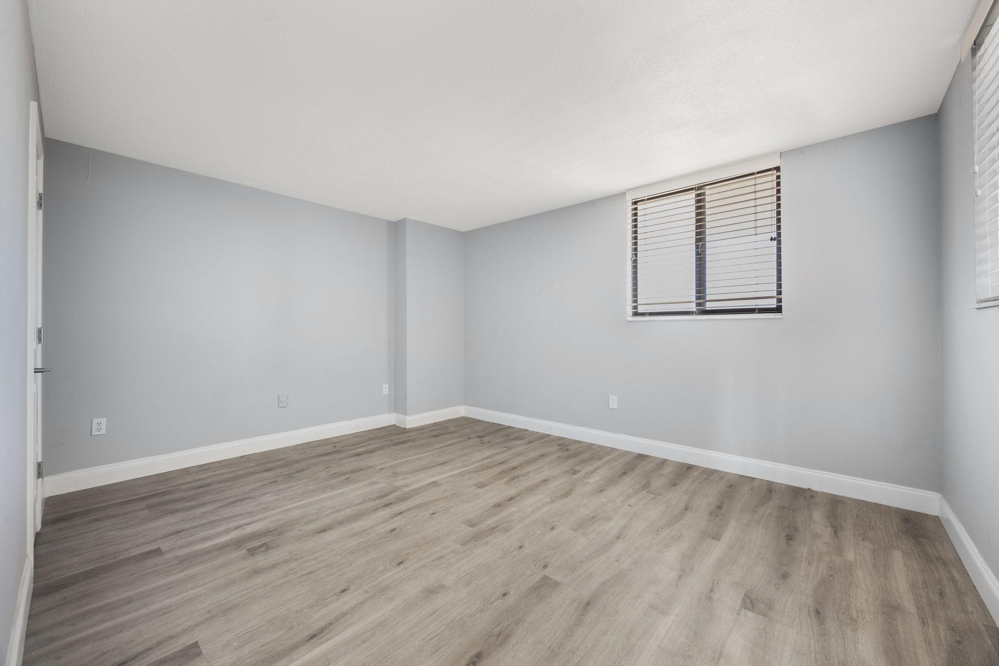 View of the secondary bedroom from the foyer entrance. Split floor plan offers privacy.