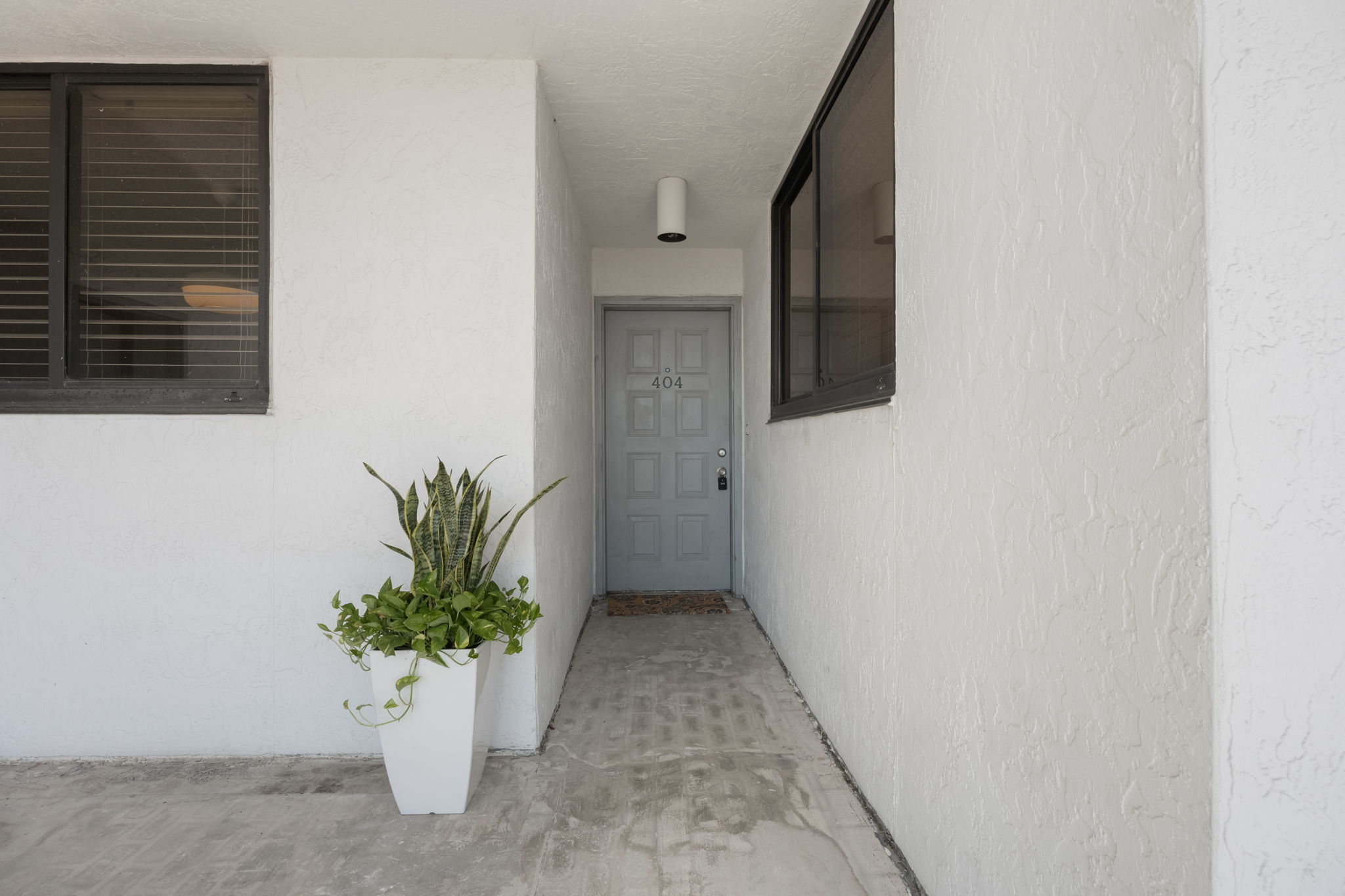 Entrance to #404. Welcome home! Note: the HOA has scheduled the replacement of the outdoor floor tiles as well as exterior pressure washing and paint to be completed in 2026. All to be paid thru the reserves. NO SPECIAL ASSESSMENT.