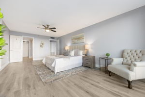Primary bedroom looking into ensuite bath to the left and entrance hall to the right off main living.
