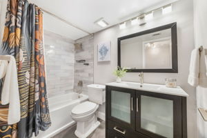 Secondary Hall Bath offers updated vanity and tub shower combo with rain shower head and beautiful subway tile.