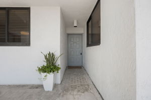 Entrance to #404. Welcome home! Note: the HOA has scheduled the replacement of the outdoor floor tiles as well as exterior pressure washing and paint to be completed in 2026. All to be paid thru the reserves. NO SPECIAL ASSESSMENT.