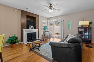 Great room with fireplace, ceiling fan and entry to courtyard.