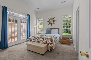 Primary bedroom with vaulted ceiling and entry to courtyard.