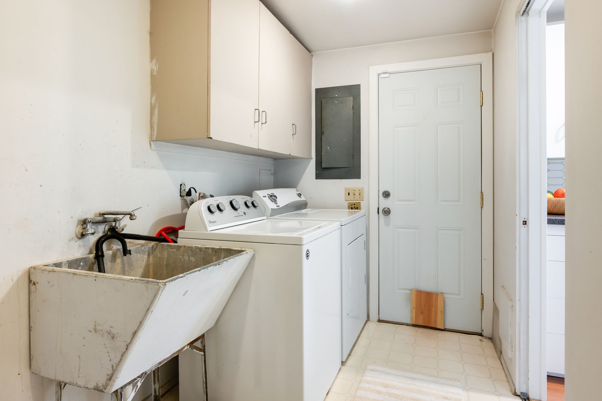 From the kitchen, you'll discover a spacious laundry room complete with a utility sink, cabinetry, and ample pantry space. This room makes household tasks a breeze and offers convenient access from the driveway, making it easy to bring in groceries and more.