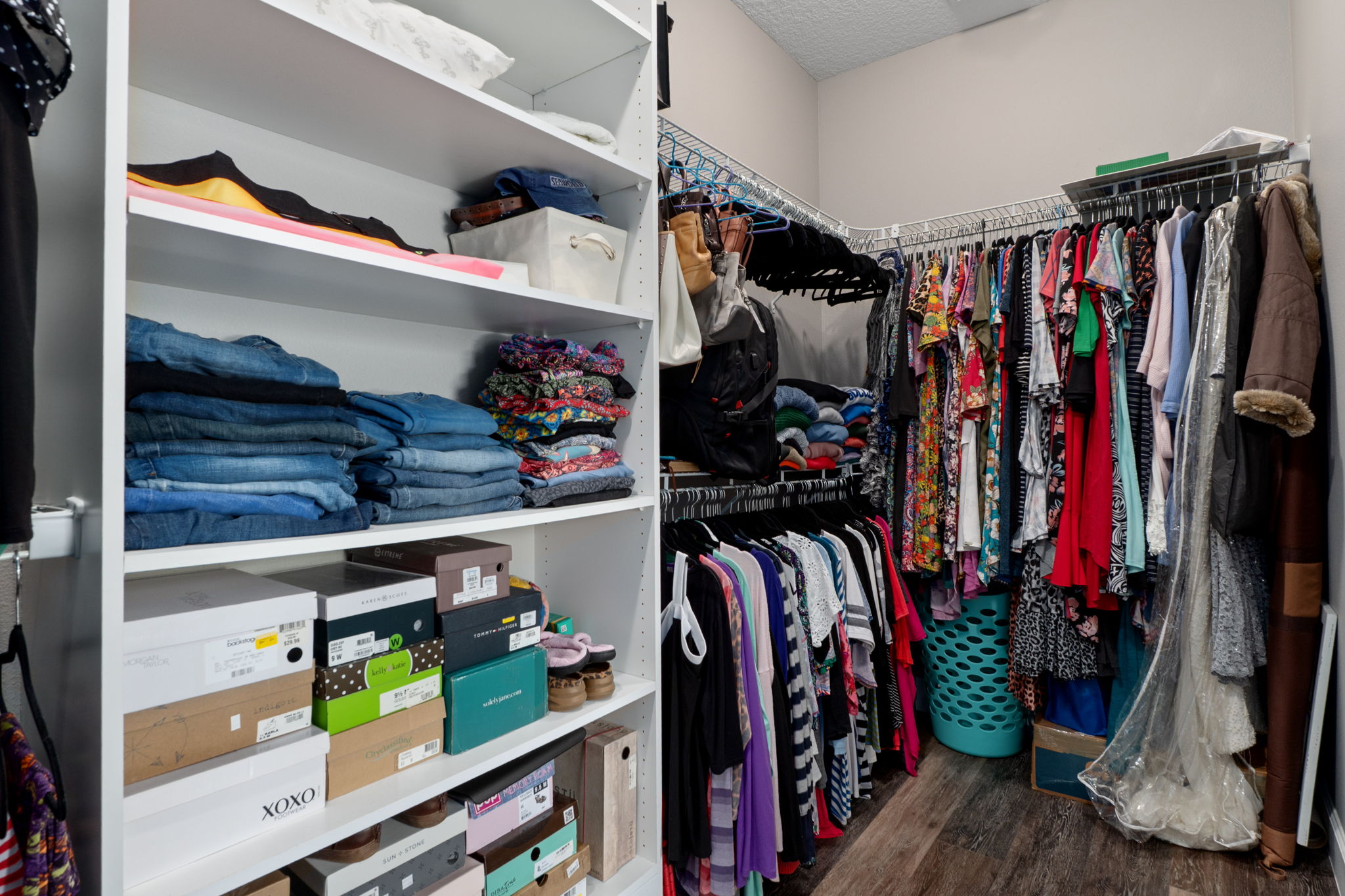 The primary suite's walk-in closet features built-in shelving.