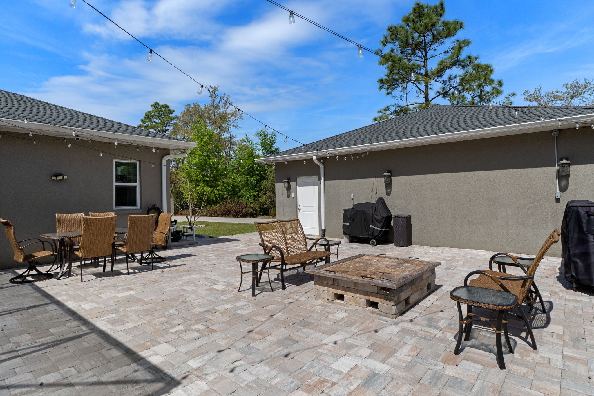 Opposite view of patio and firepit. The side door to the detached garage makes for easy access.