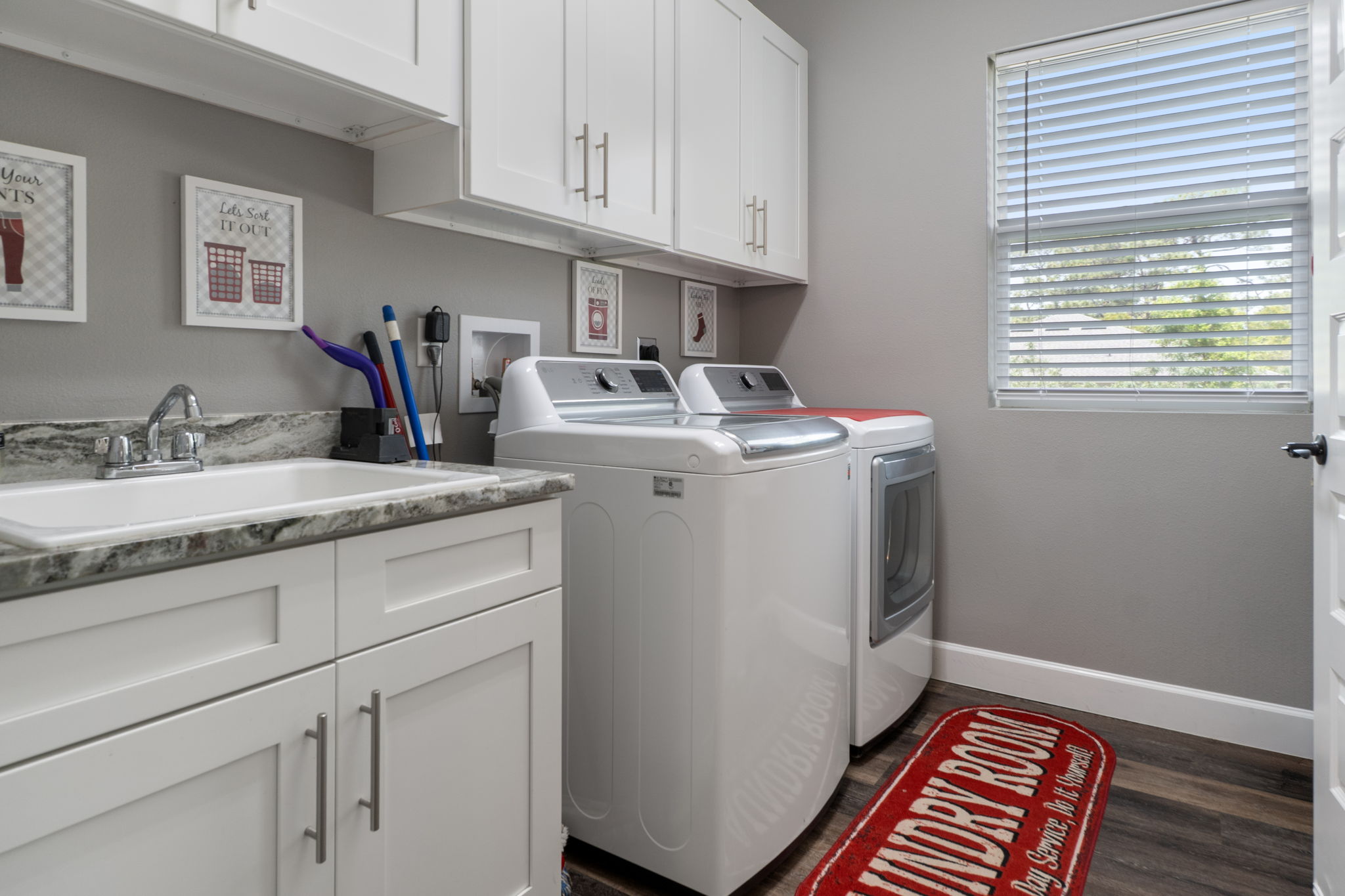 The dedicated laundry room provides additional storage and a convenient utility sink.