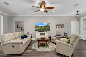 The great room, opposite the kitchen. The closed solid door on the right leads to the flex room, currently used as an office. The open doorway on the left leads to the two guest bedrooms and hall bath.
