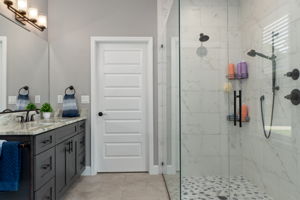 At the opposite end of the primary bath, the closed door leads into the separate laundry room. Such a convenient feature, just steps away from the primary closet.