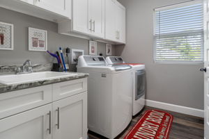 The dedicated laundry room provides additional storage and a convenient utility sink.