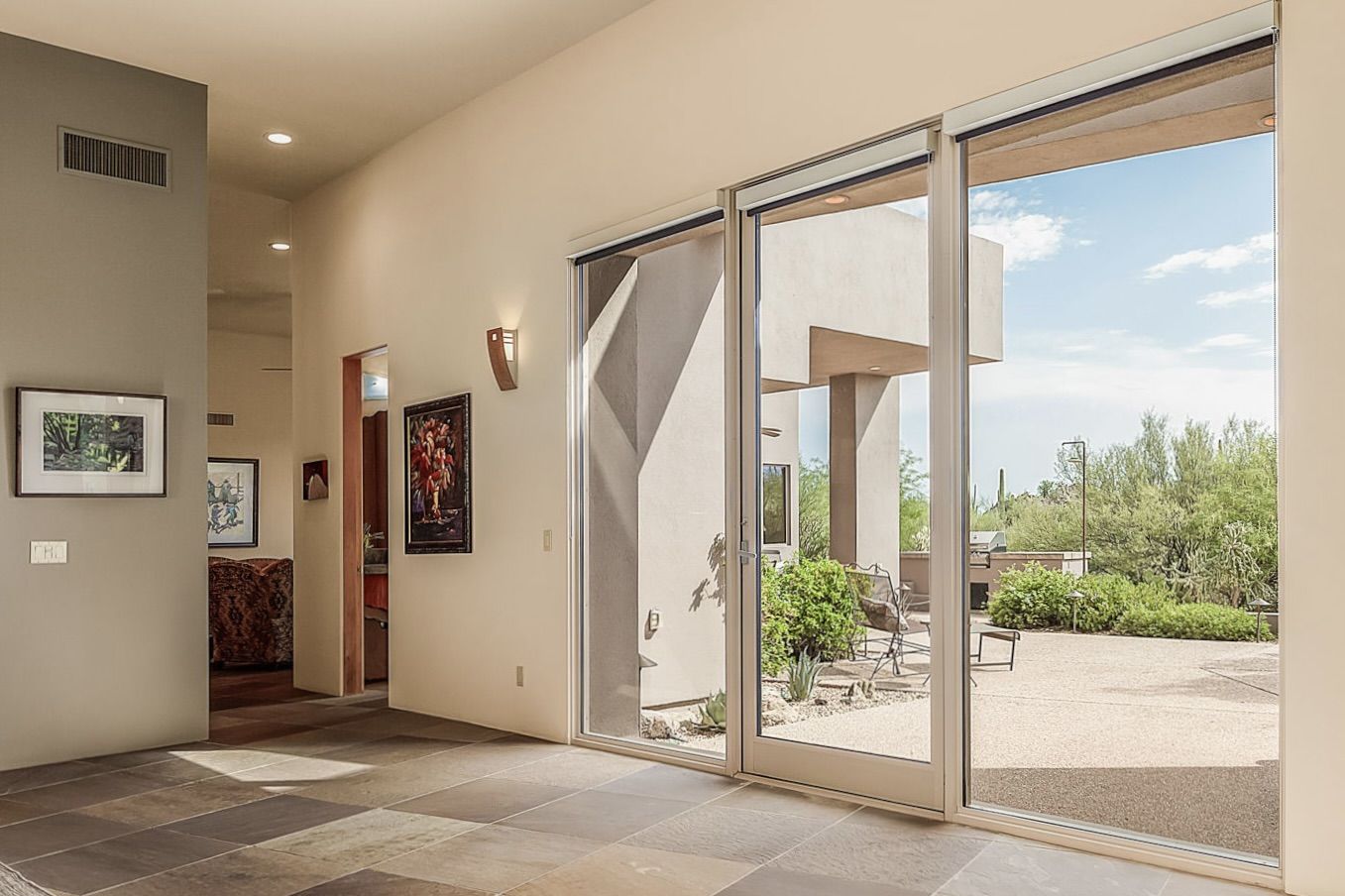 The large window wall with a glass slider is located across from the formal dining area and offers stunning west-facing views and access to the expansive rear courtyard.