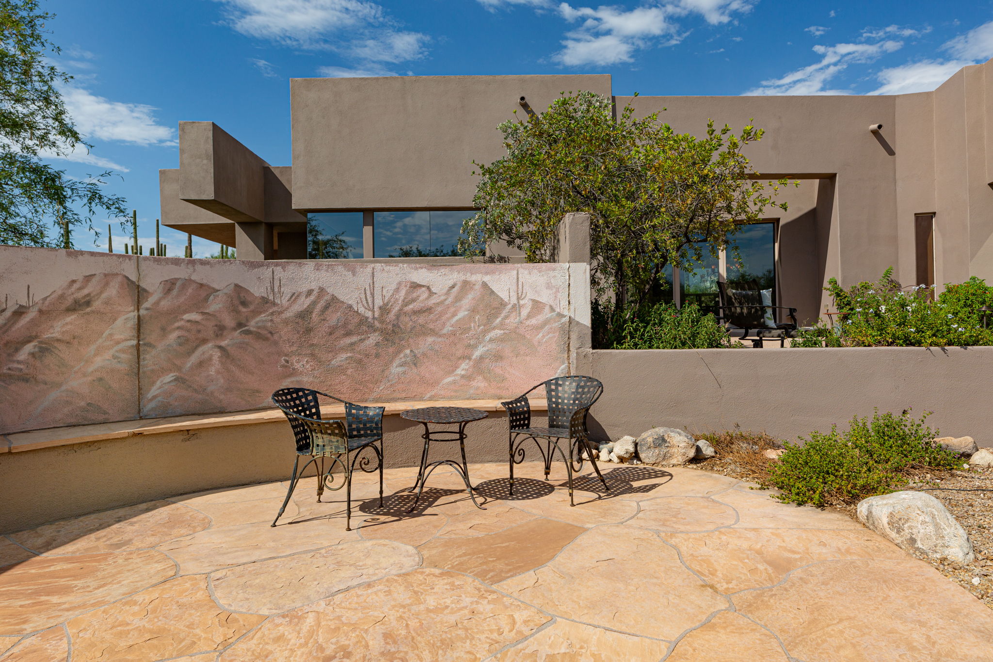 The rear flagstone patio with custom mural and bench seat is a great addition for entertainment purposes.