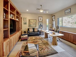 Den/Study w/ ensuite bath features custom built-in cabinets that provide ample storage and can accommodate three televisions.