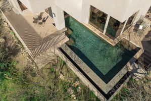 Aerial view encompasses the primary bedroom's large private deck with pool access, and the rear courtyards private pool patio.