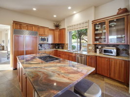 Gorgeous granite island w/ storage, gas cooktop, and seating for two.