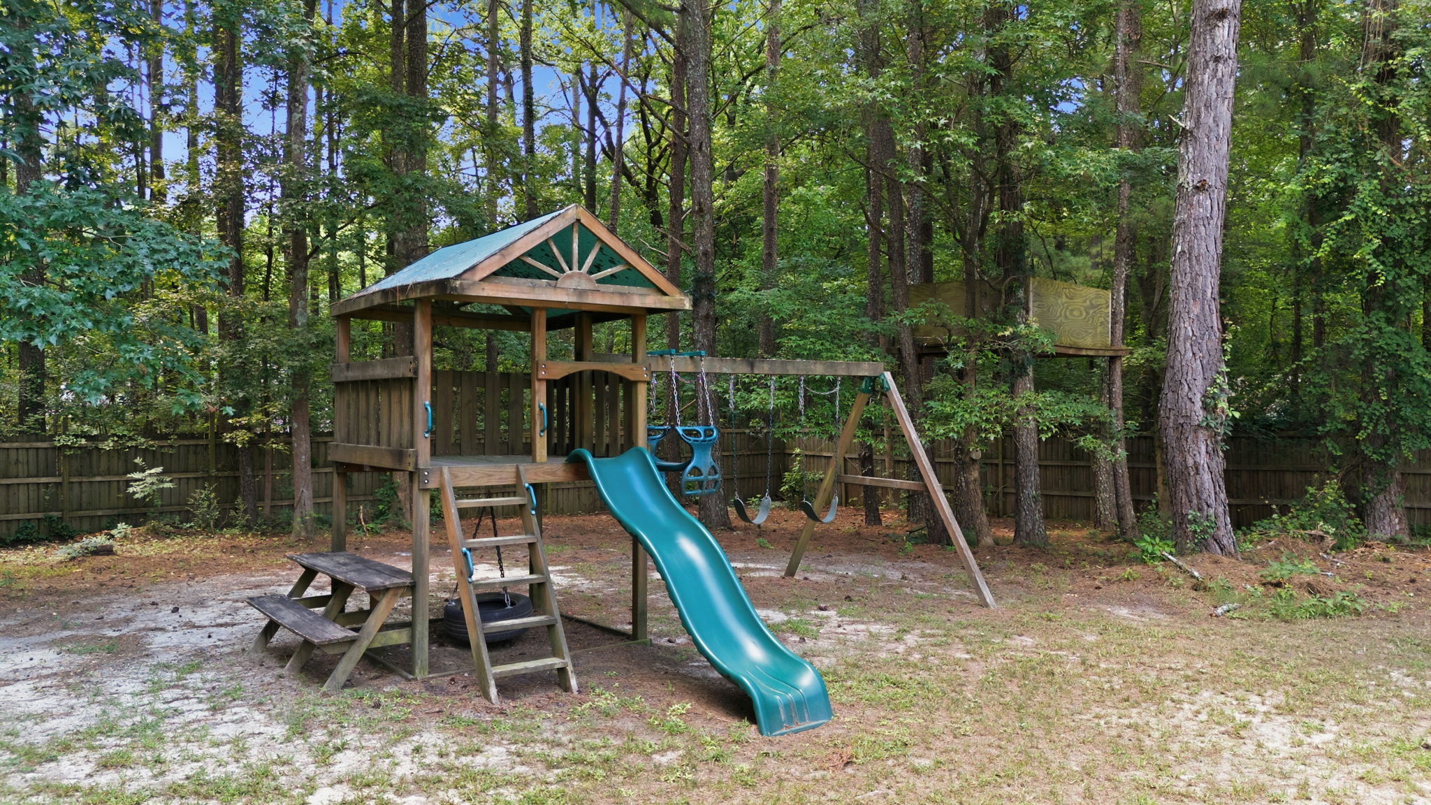 Wooden playset beneath a shaded canopy