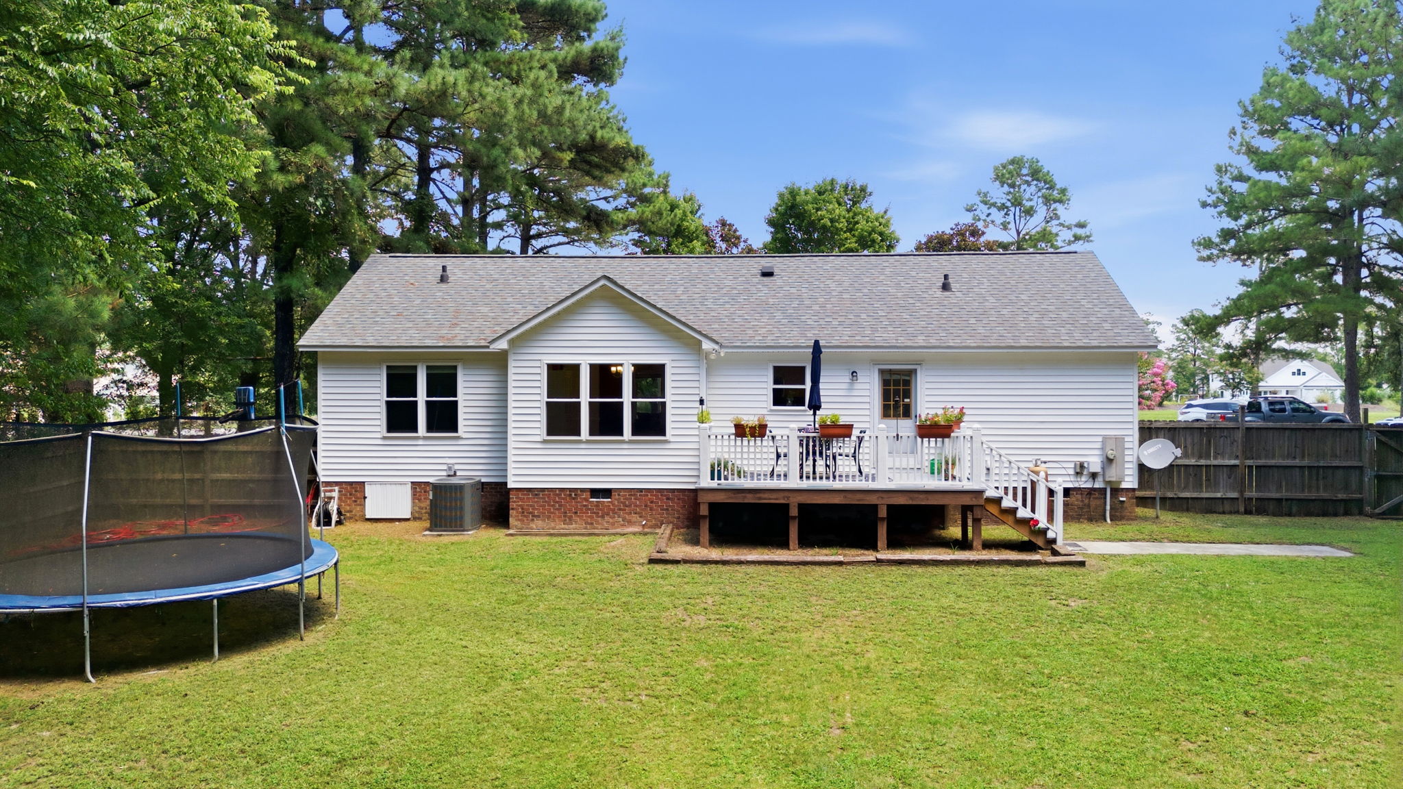 Rear exterior with deck and broad lawn