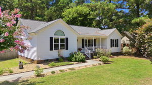 Welcoming ranch framed by mature trees
