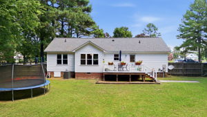 Rear exterior with deck and broad lawn