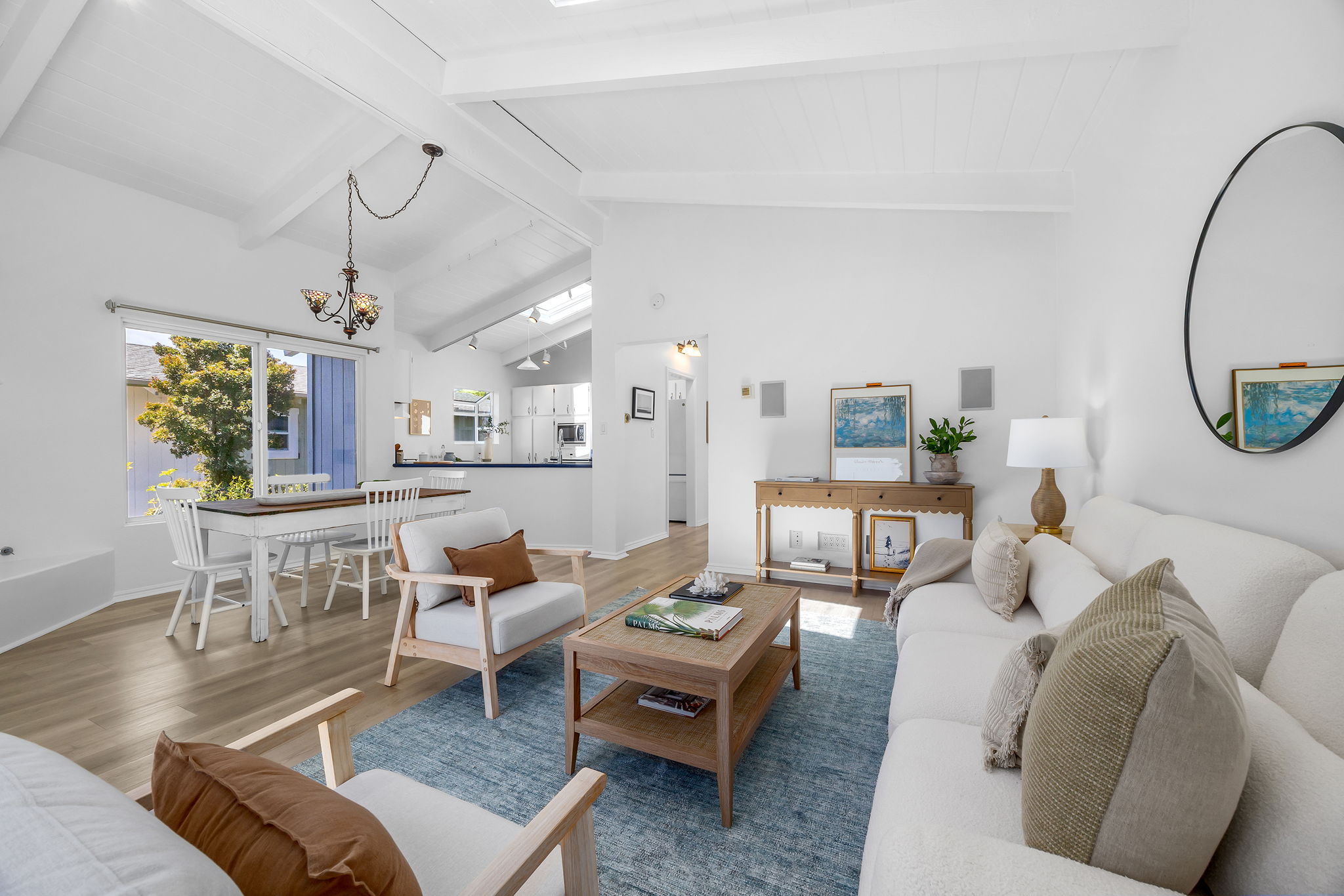 Open living/dining room with vaulted ceilings and a skylight.