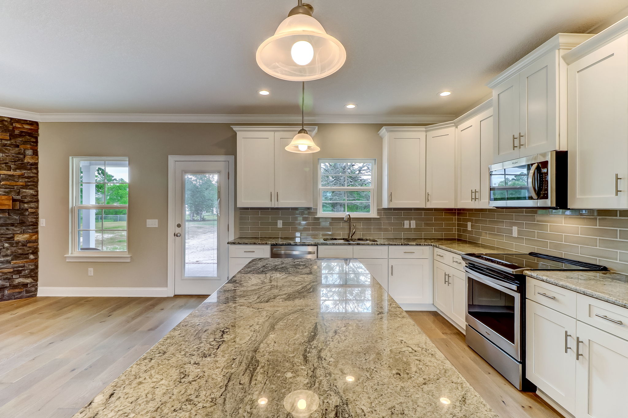 The kitchen is bright and elegant with granite countertops and island, 42' soft close cabinets, and Whirlpool appliances.