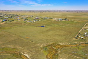 Real aerial view of property with seasonal pond