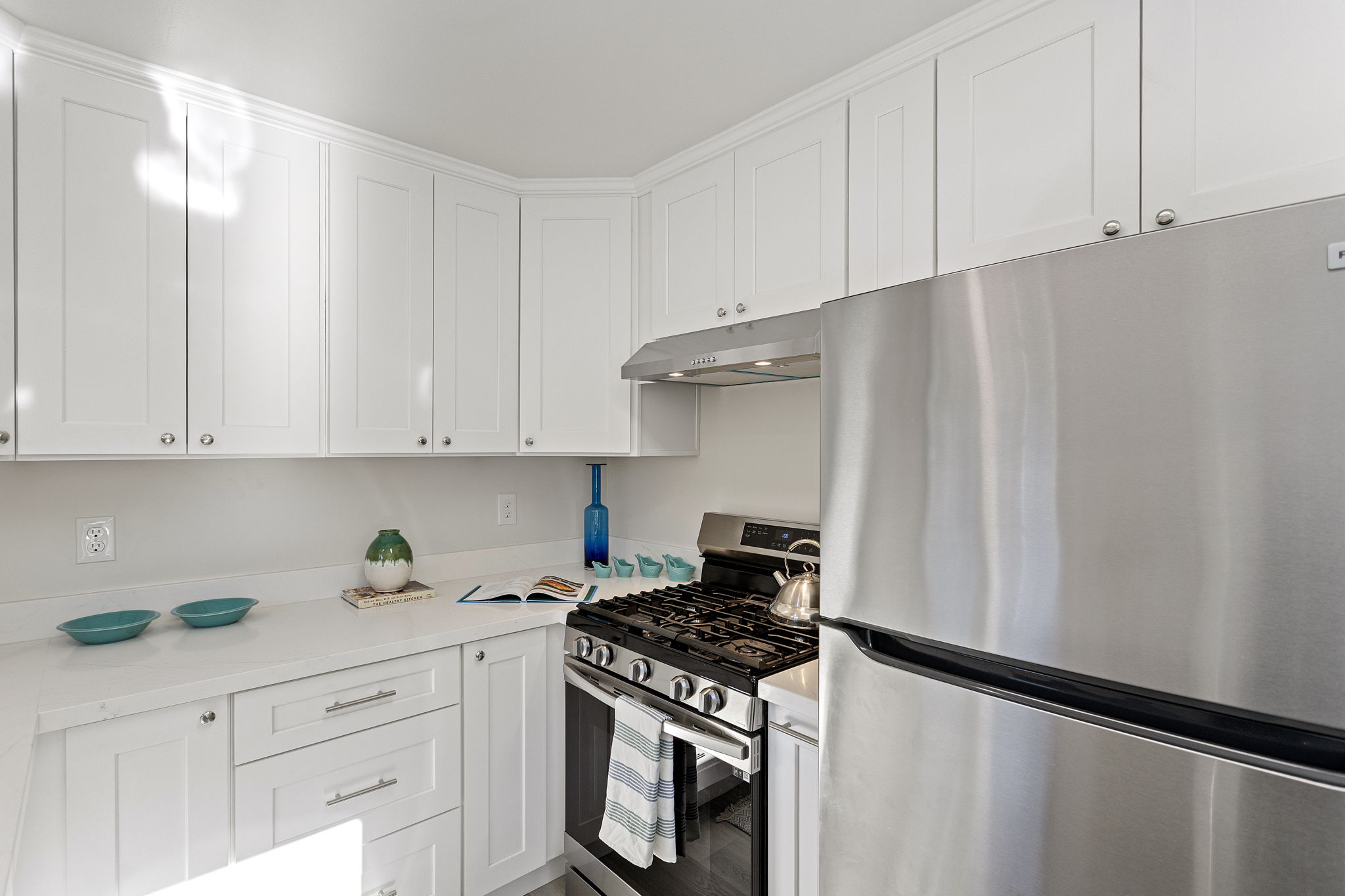 Stainless appliances, updated lighting, and generous counter space make the kitchen both practical and inviting.