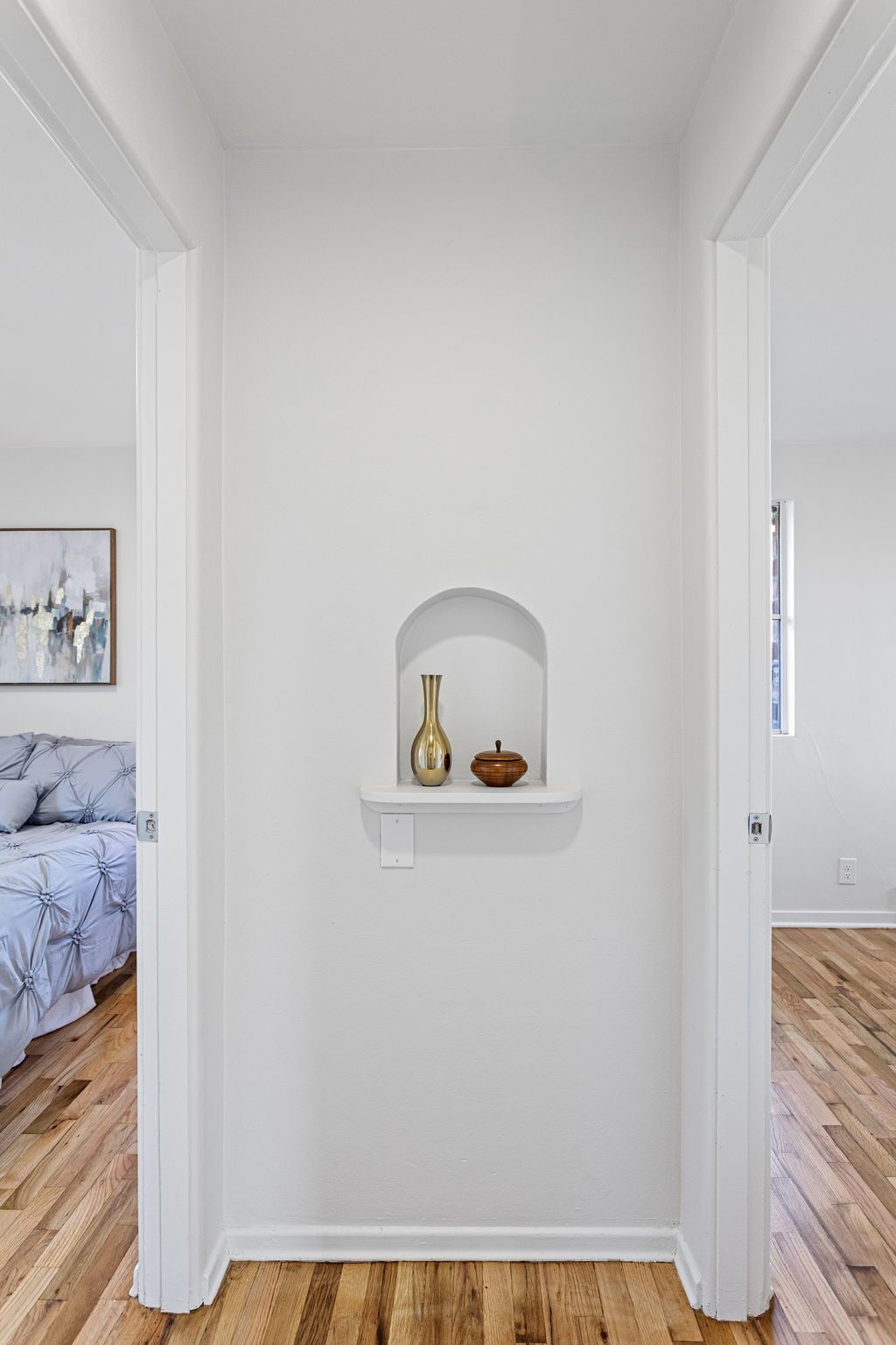 An arched display niche introduces architectural character, balanced by generous built-in linen storage across the hall.