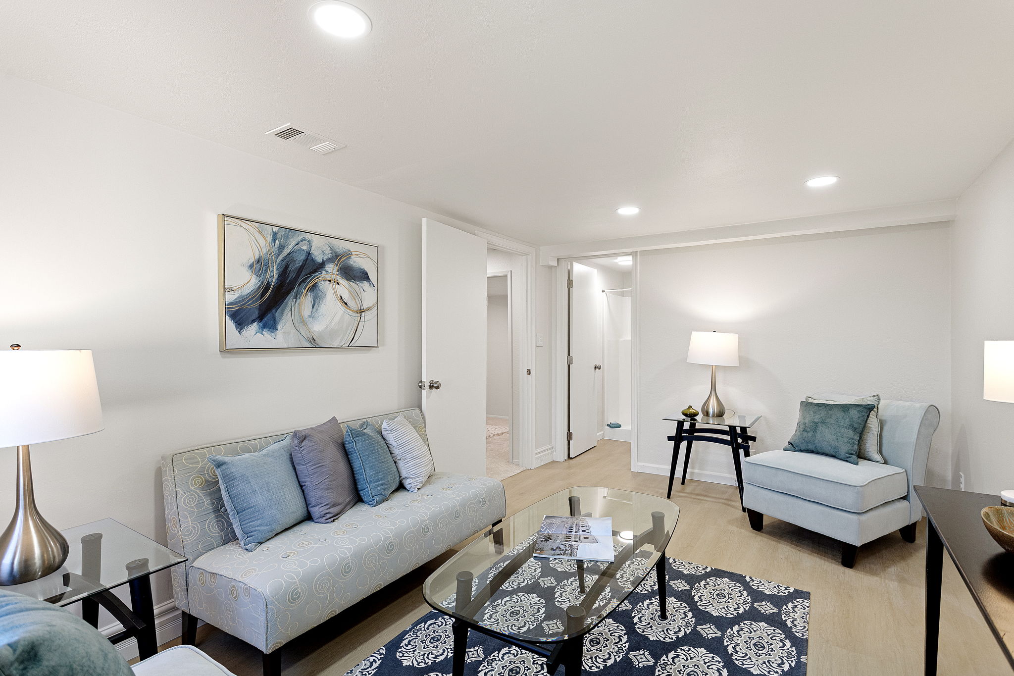 This family room connects directly to the adjacent ¾ bath and laundry area, with new LVP flooring adding durability and ease to the lower level.