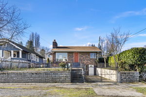Gated front drive and mature plantings frame the home, balancing openness with a sense of separation from the street.