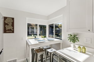 Just off the living room, the kitchen offers a bright corner eating space with natural light from multiple windows.
