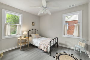 Rear 1st floor bedroom with new Anderson windows, LVP flooring, & ceiling fan.