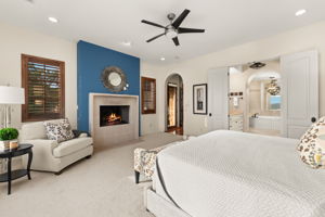 Unwind in the primary suite, where a warm fireplace creates a serene and elegant escape.