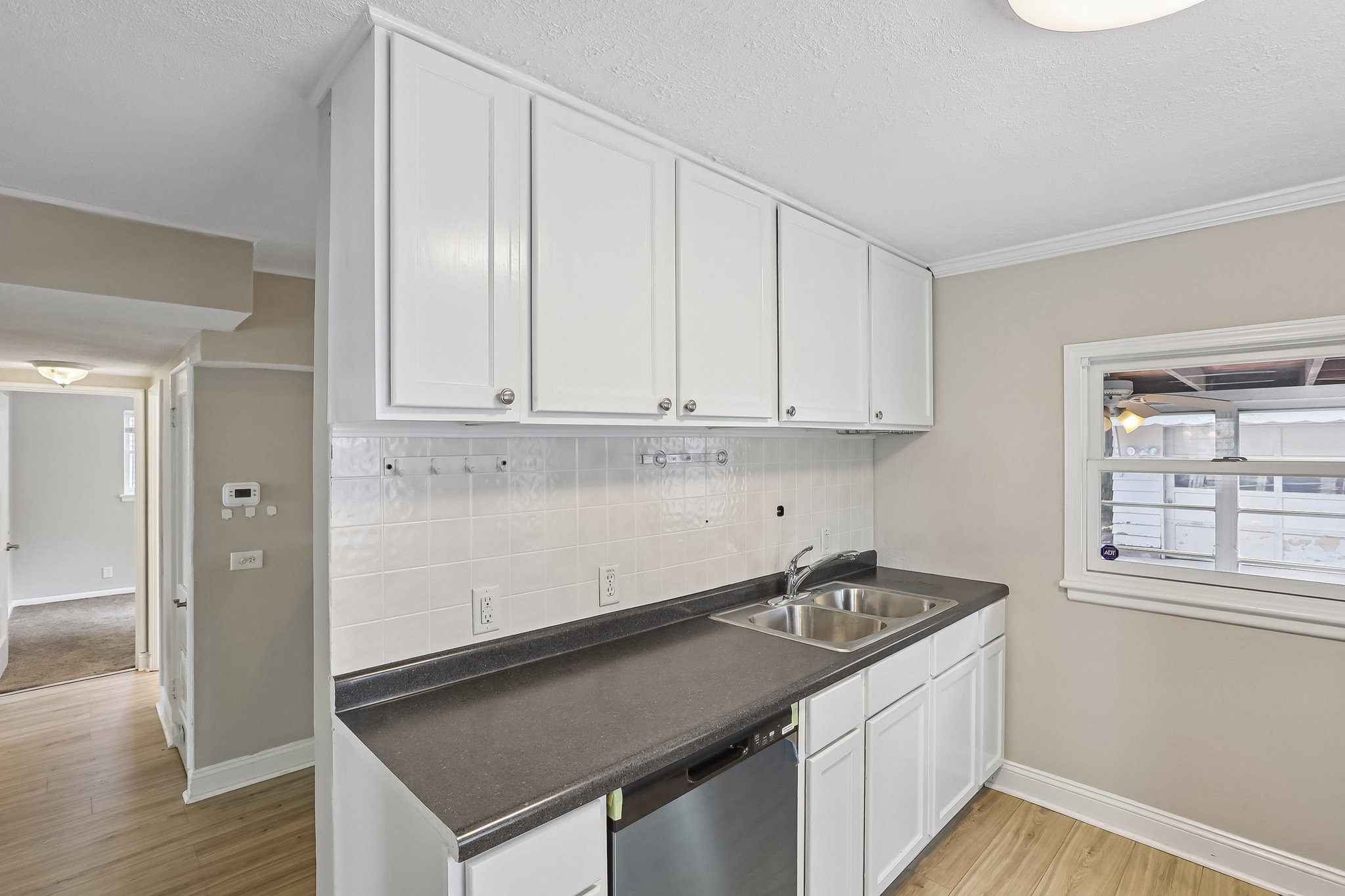 Bright white cabinetry, generous counter space, and a tiled backsplash make meal preparation both practical and inviting.