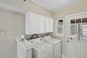 A dedicated laundry with storage, a utility sink, and exterior access helps keep daily routines organized.