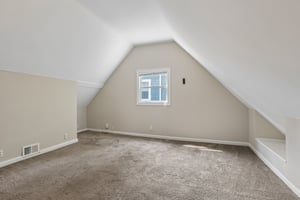 Upstairs spacious bonus room with charming sloped ceilings creates a cozy retreat with unmistakable Cape Cod character