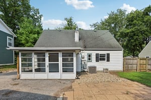 A paved patio and fenced yard set the stage for summer dinners, weekend cookouts, and evenings under the trees
