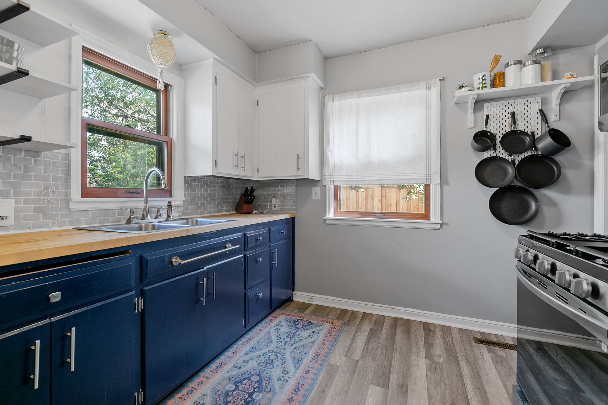 The kitchen at 5549 27th Avenue S combines stainless steel appliances with deep-blue lower cabinets and butcher-block countertops.