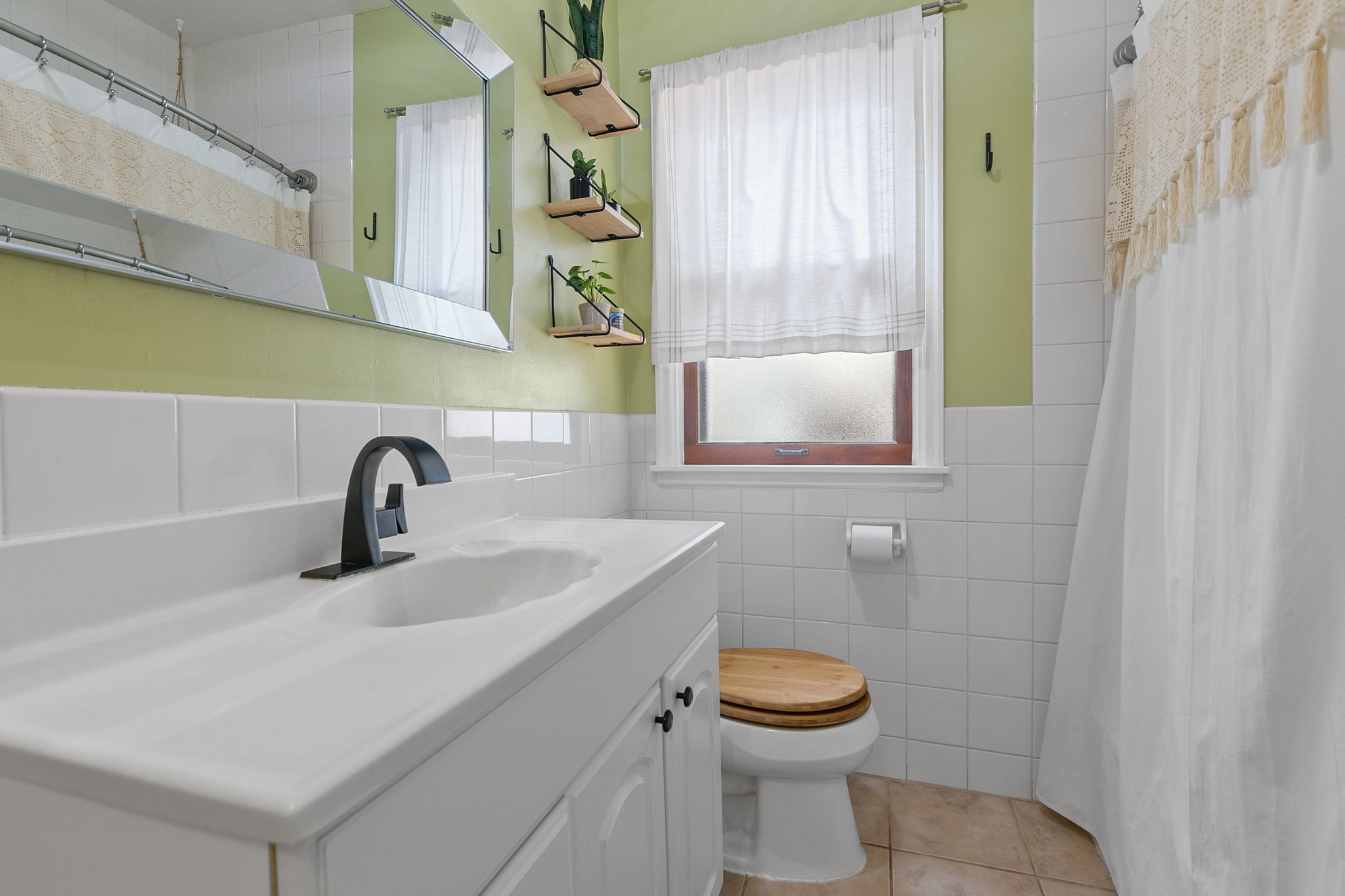 The bathroom at 5549 27th Avenue S is accessible from the main level of the home, with a conveniently wide vanity countertop and a full-height shower + bathtub.